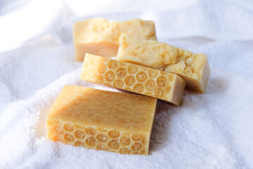 Honey soap is placed on the towel on the wooden table. - 398675898