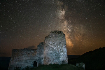 ruins of old castle in the night under milky way