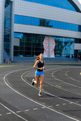Fototapeta premium Athlete runner running on athletic track training her cardio.