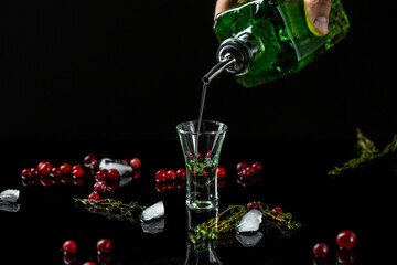 Alcohol, luxurious spirits and dangerous liquor absinthe, pouring, green bottle of strong spirit