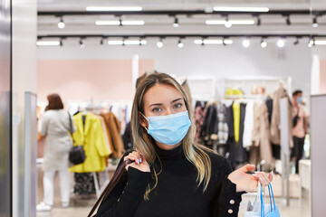 Female customer shopping in a boutique with face mask