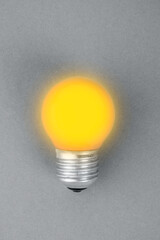 Illuminating Yellow lamp on trendy ultimate grey background.