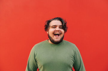 Portrait of a cheerful bearded young man with a broad toothy smile, feeling happy and positive,...