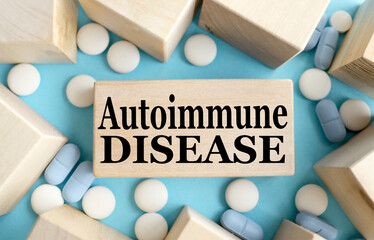 AUTOIMMUNE DISEASE. TEXT ON A WOODEN BAR on a blue background. Medical concept.