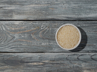 Cereal of rice in the bowl on wooden background.