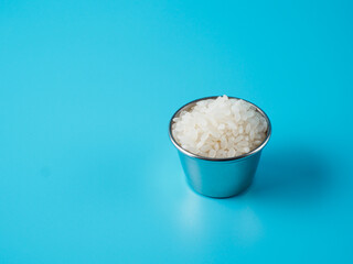 Rice cereal in the small bowl on blue background.