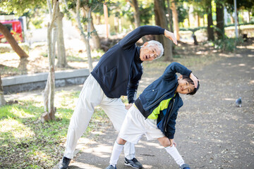 祖父と孫が仲良くストレッチをしている