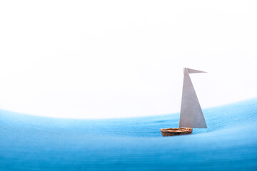 Nut shell sailing ship against white background.
Segelschiff aus Nussschale vor weißem Hintergrund.