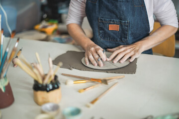 Fototapeta na wymiar Hands view of woman making ceramics objects inside creative pottery studio - Art and workshop concept