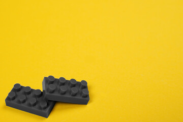 Two ultimate gray constructor blocks on illuminating yellow background with space for text. Main color trend of the year 2021.