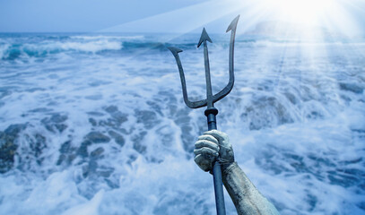 The mighty god of sea and oceans Neptune (Poseidon, Triton). Neptun's trident as symbol strength, power and unrestraint. Fragment of an ancient statue. Free copy space. © zwiebackesser