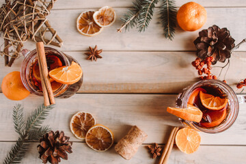Hot mulled wine with fruits and spices on wooden background. Winter warming drink for the holidays.