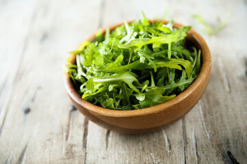 Healthy fresh arugula in a wooden bowl
