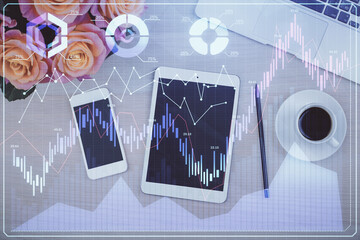 Double exposure of forex graph hologram over desktop with phone. Top view. Mobile trade platform...