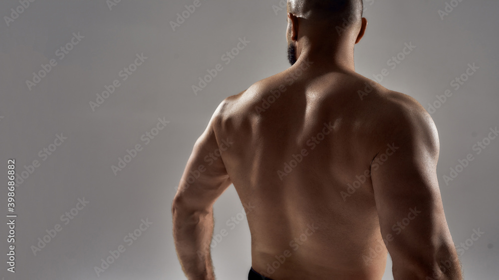 Wall mural Figure of young caucasian bodybuilder making back pose - Wall murals