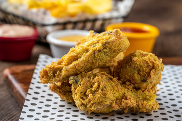 Baked chicken wings with sesame and sauce on wooden background