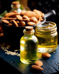 Concept of organic vegetable oils for cooking and cosmetology. Almond essential oil on a dark wooden background