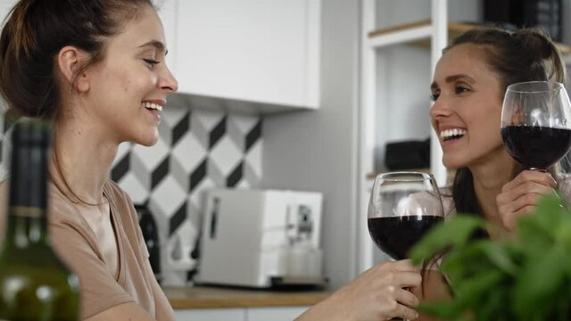 Handheld video of two women drinking red wine at home. Shot with RED helium camera in 8K