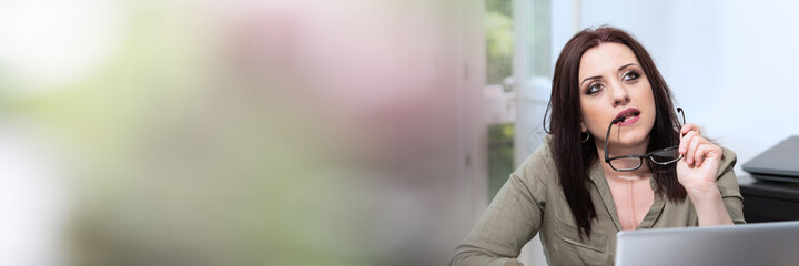 Thoughtful businesswoman looking up; panoramic banner