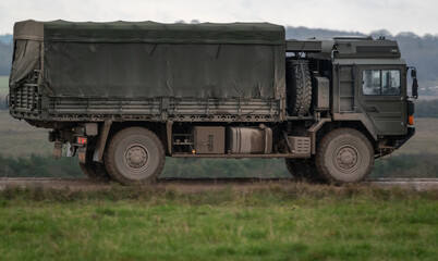 Obraz premium MAN SV 4x4 army logistics vehicle driving along a stone track on a military exercise, Salisbury Plain Wiltshire UK