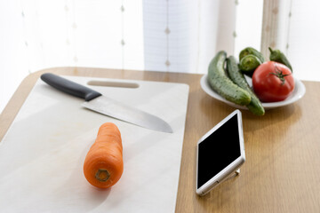 スマートフォンを見ながら料理をするイメージ