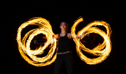 Creating incredible patterns of fire. Sexy woman roll dragon staff in darkness. Rotational fire staff manipulation. Manipulating style. Night performance. Party festival. Holiday celebration