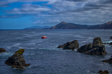 A ship in the sea and among rocks