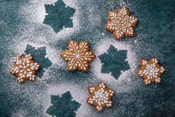 Christmas homemade gingerbread cookies in the shape of snowflakes and herringbone on a turquoise...