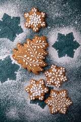 Christmas homemade gingerbread cookies in the shape of snowflakes and herringbone on a turquoise background. Holiday sweets for decoration and gifts.