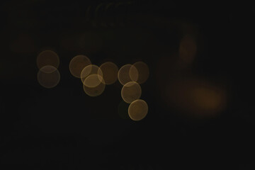 Texture of a yellow flare bokeh chained on black backgrounds. © jbstocks