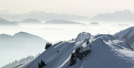 Snow Mountains Panorama in low lying inversion valley fog. Silhouettes of foggy Mountains. Scenic...