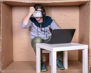 employee with virtual reality glasses working in his home cardboard office