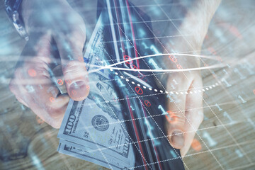 Multi exposure of forex graph drawing hologram and USA dollars bills and man hands. Technical Analysis concept.