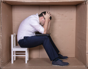 broken businessman in a cardboard office, stress and depression from overwork