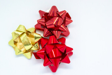 Gold and red gift wrap bows on a white background