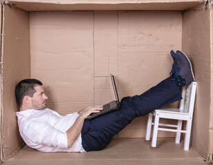 broken businessman in a cardboard office, stress and depression from overwork