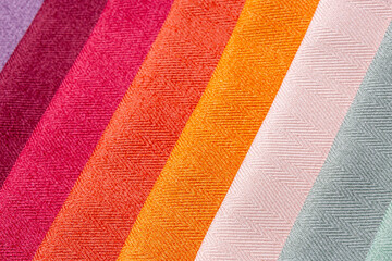 Slant colorful set of comparison interior decoration sample swaps of textured curtain fabric with various shades and evenly lit colors. Textured background.