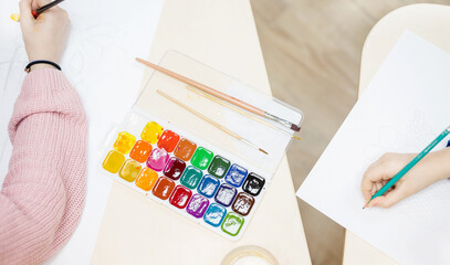 Children's hands drawing with paint brushes. Drawing lesson, creative children.