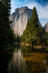 Fototapeta na wymiar Scenic view of the merced river in the Yosemite valley, with the rocky mountains reflected on the water, in California, USA.
