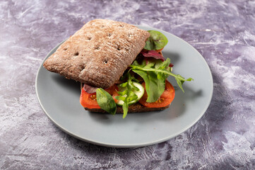 An angle view of a sandwich with vegetables. Sandwich on a plate.
