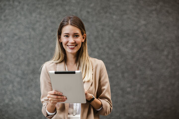 Portrait of successful businesswoman holding digital tablet