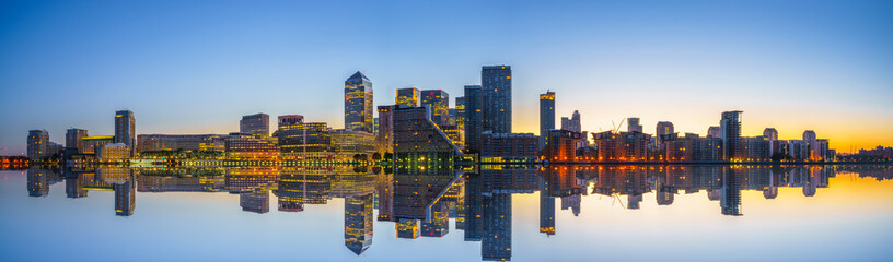 Canary Wharf business district of London at sunrise with reflection