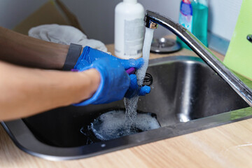 Beauty and hygiene industry. Master in medical gloves washes tools with water