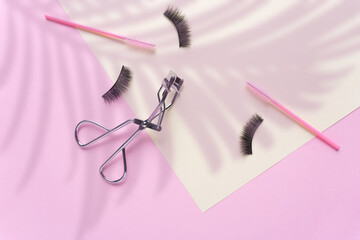Creative concept beauty fashion photo of lashes extensions brush on pink yellow background.