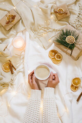 Young woman's hands holding mug with hot chocolate. Warm and cozy atmosphere preparing for holidays, christmas and celebration.