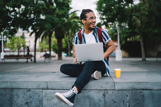 Content Black Male Freelancer Using Laptop On City Street On Summer Day