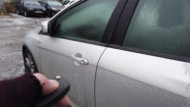 Europe, Ukraine, Kiev - December 2020: Opening of the icy car. The car does not open due to ice. Warming up the car during icy conditions. The car door is frozen and won't open.