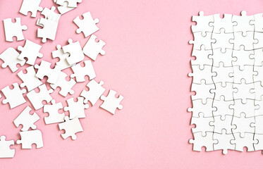 white puzzle pieces on pink background