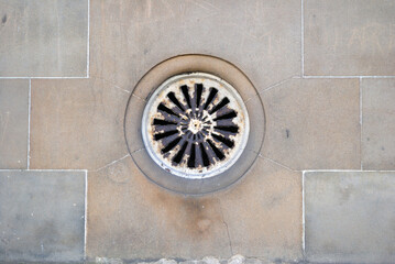 Close Up of Old Victorian Circular Iron Vent in Smooth Stone Wall