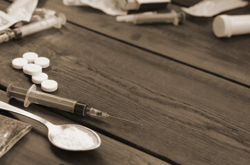 A lot of narcotic substances and devices for the preparation of drugs lie on an old wooden table